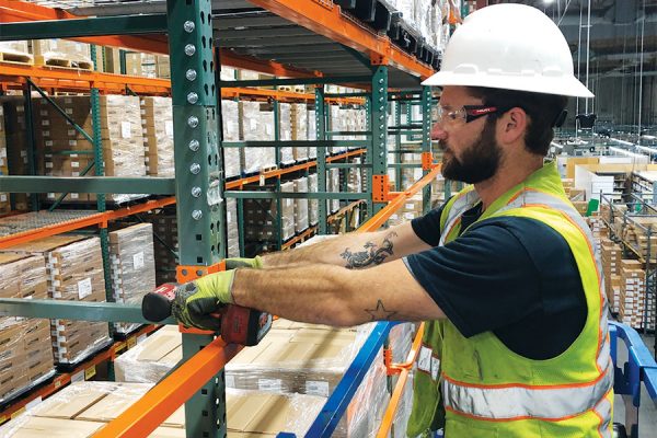 Rack Store Expert Looking Over Materials Stored on Pallet Racks